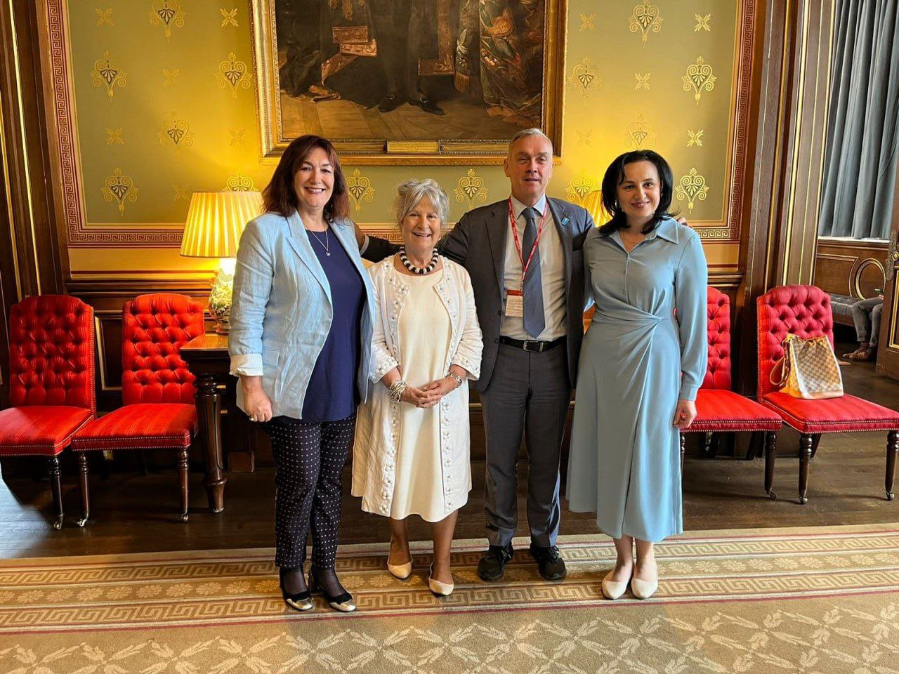 Four people photographed indoors during a ministerial study visit